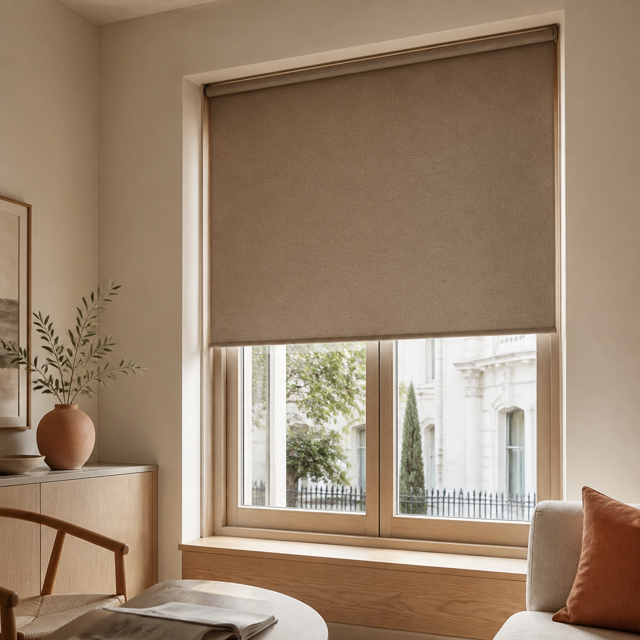 Warm taupe roller blind partially lowered over a timber-framed window